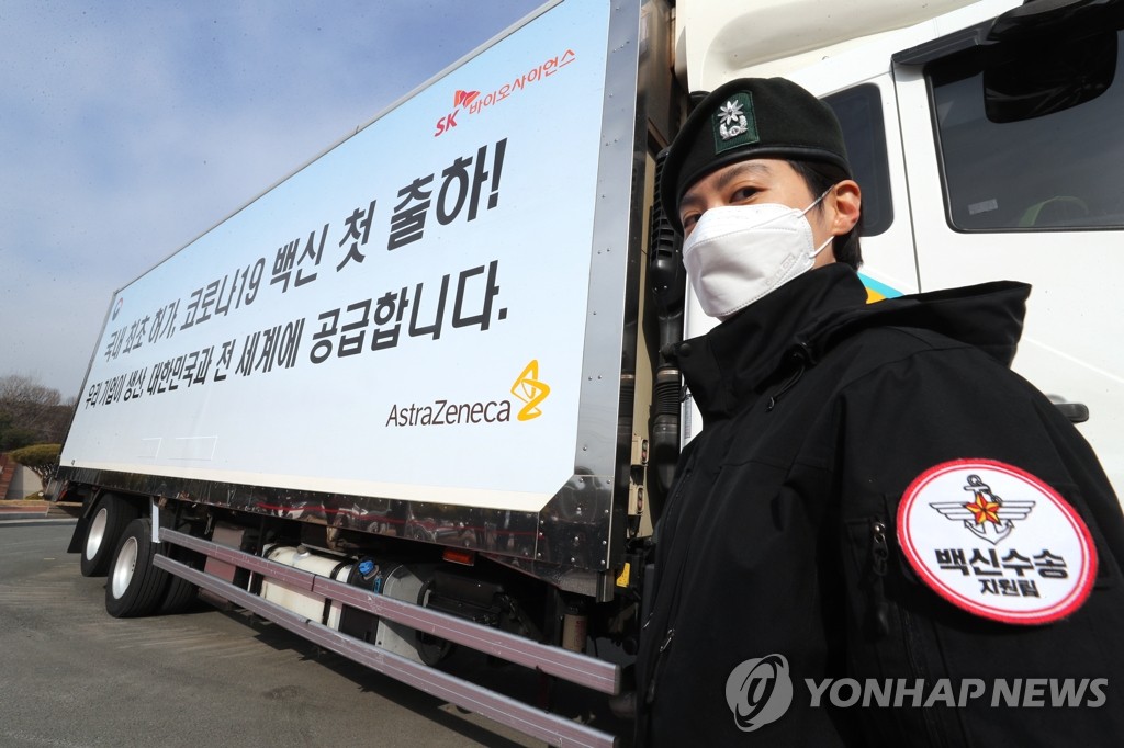 Un officiel militaire à côté d'un camion transportant des vaccins d'AstraZeneca à Andong, à 268 km au sud-est de Séoul, le mercredi 24 février 2021. 