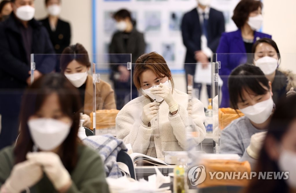 Nurses practice extracting vaccines from vials during a training session for COVID-19 vaccinations in Seoul on March 4, 2021. (Yonhap)
