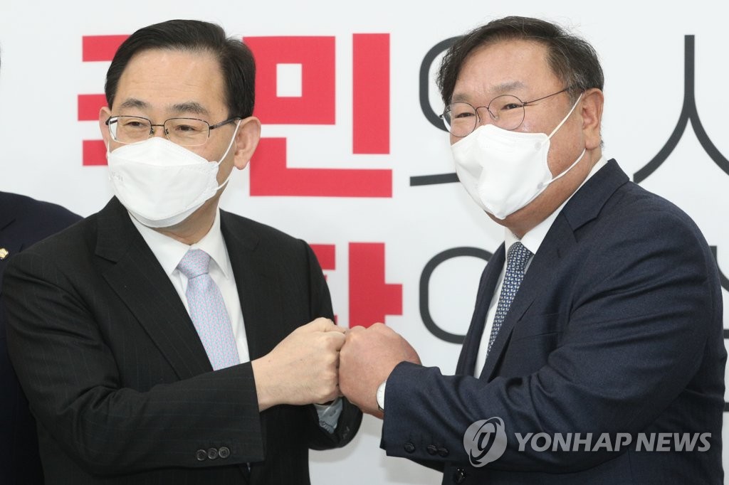 Rep. Kim Tae-nyeon (R), acting chief and floor leader of the ruling Democratic Party, bumps fists with Rep. Joo Ho-young, floor leader of the main opposition People Power Party, at the National Assembly in Seoul on March 12, 2021. (Yonhap)