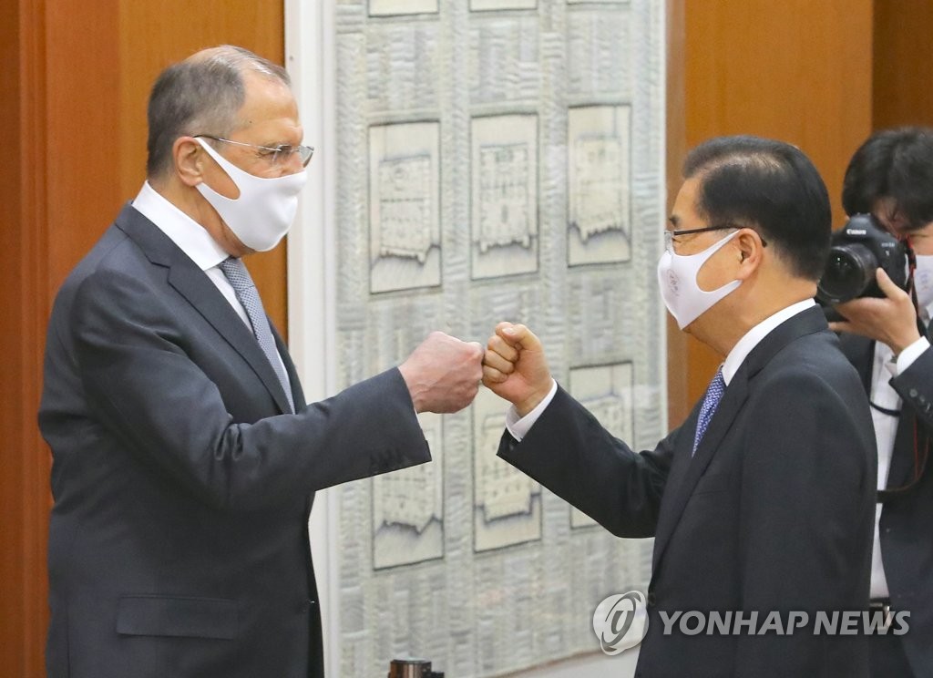 In this file photo, Foreign Minister Chung Eui-yong (R) and his Russian counterpart, Sergey Lavrov, fist bump each other at the foreign ministry office in central Seoul during the Russia diplomat's visit to South Korea on March 25, 2021. (Pool photo) (Yonhap)