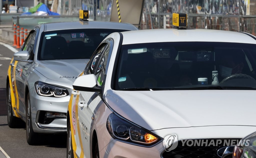 Taxis affiliated with Kakao Mobility's taxi-hailing service operate outside Seoul Station in central Seoul in this file photo taken on April 8, 2021. (Yonhap)