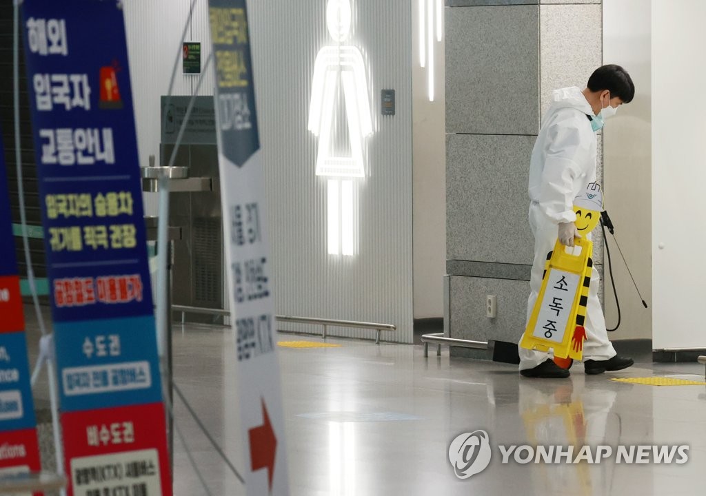 仁川国際空港の到着ロビーにあるトイレの消毒作業を行う防疫関係者＝（聯合ニュース）