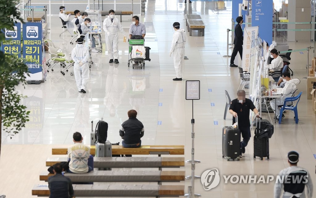 Foreign arrivals follow instructions from health care workers at Incheon International Airport, west of Seoul, on May 5, 2021, in this file photo. (Yonhap)