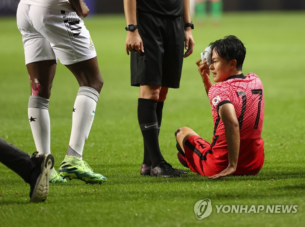 Lee Seung-woo (R) of the South Korean men's Olympic football team stays on the ground after a collision with Jonah Attuquaye of Ghana during a friendly match at Jeju World Cup Stadium in Seogwipo, Jeju Island, on June 15, 2021. (Yonhap)