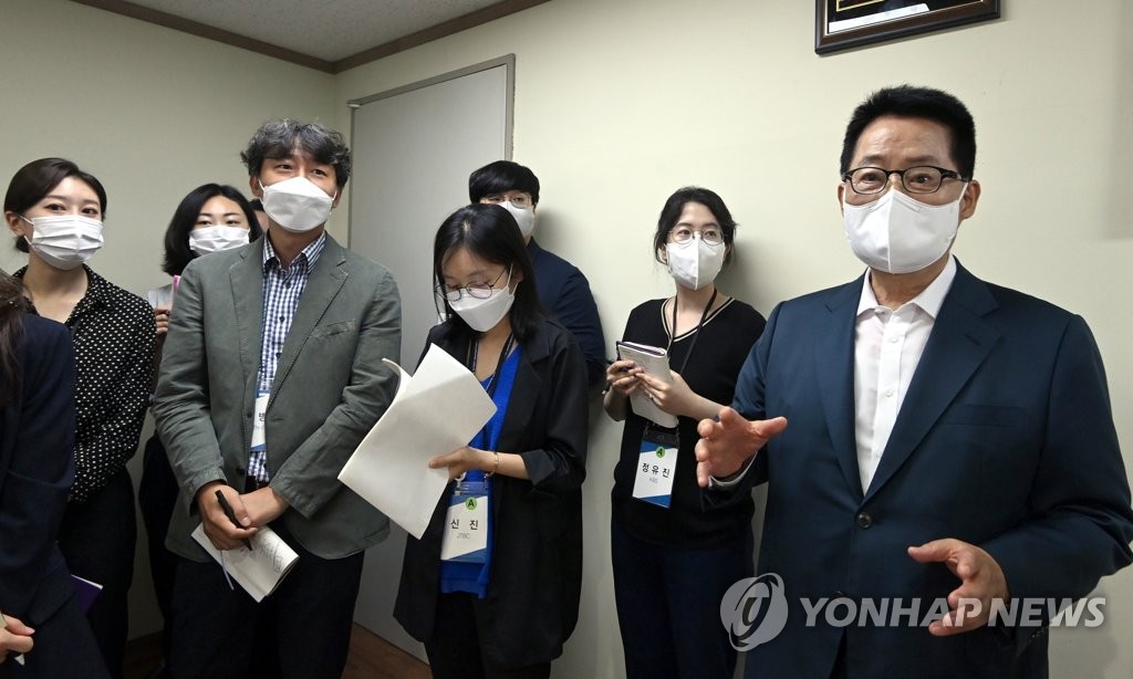 This photo provided by the joint press corps shows NIS Director Park Jie-won (far R) speaking with a group of reporters on a tour of the North Korean Refugee Protection Center located south of Seoul on June 23, 2021. (Yonhap) 