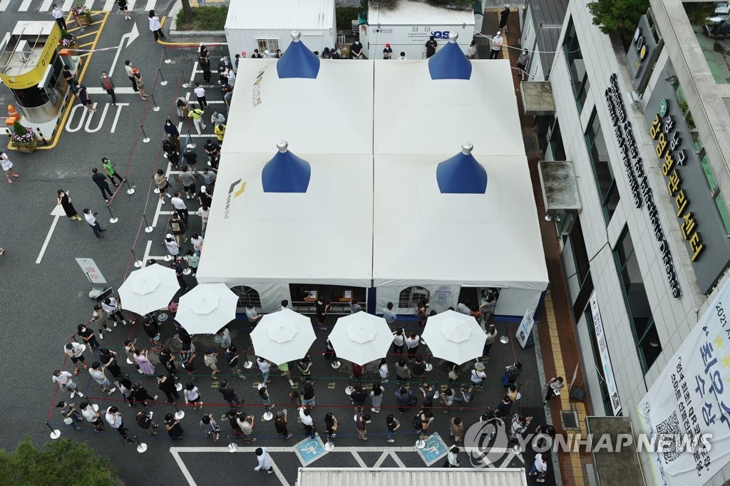 Citizens wait in line to receive COVID-19 tests on July 11, 2021, at a makeshift testing site in southern Seoul as the new virus cases rose above 1,300 for the third straight day. (Yonhap)