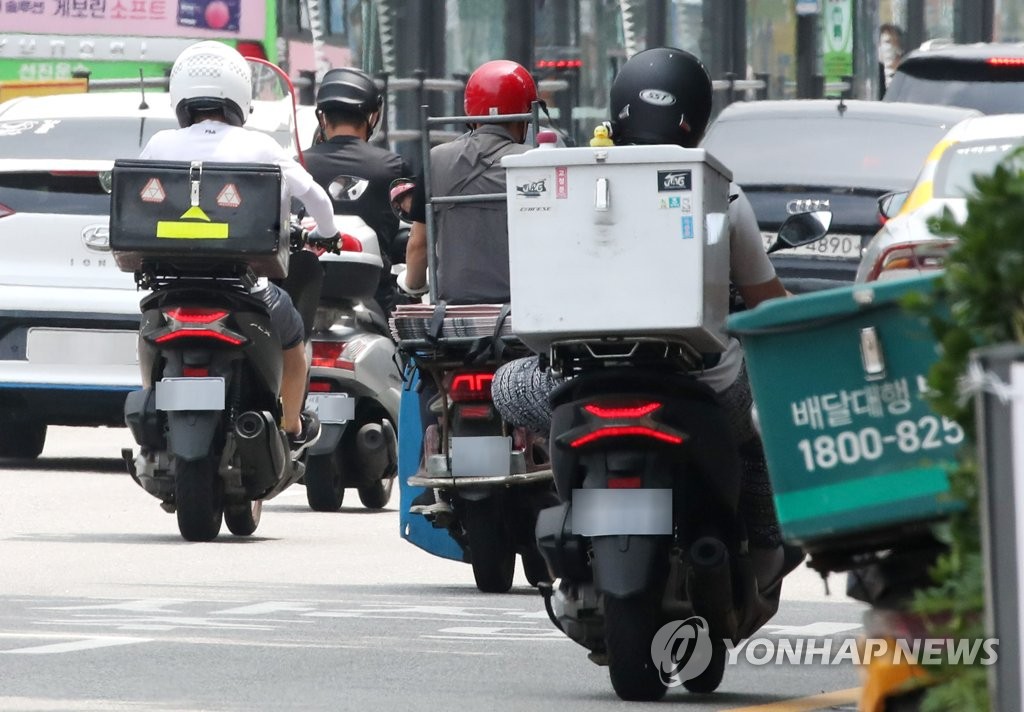 Delivery motorcycles run in central Seoul on July 12, 2021. (Yonhap)