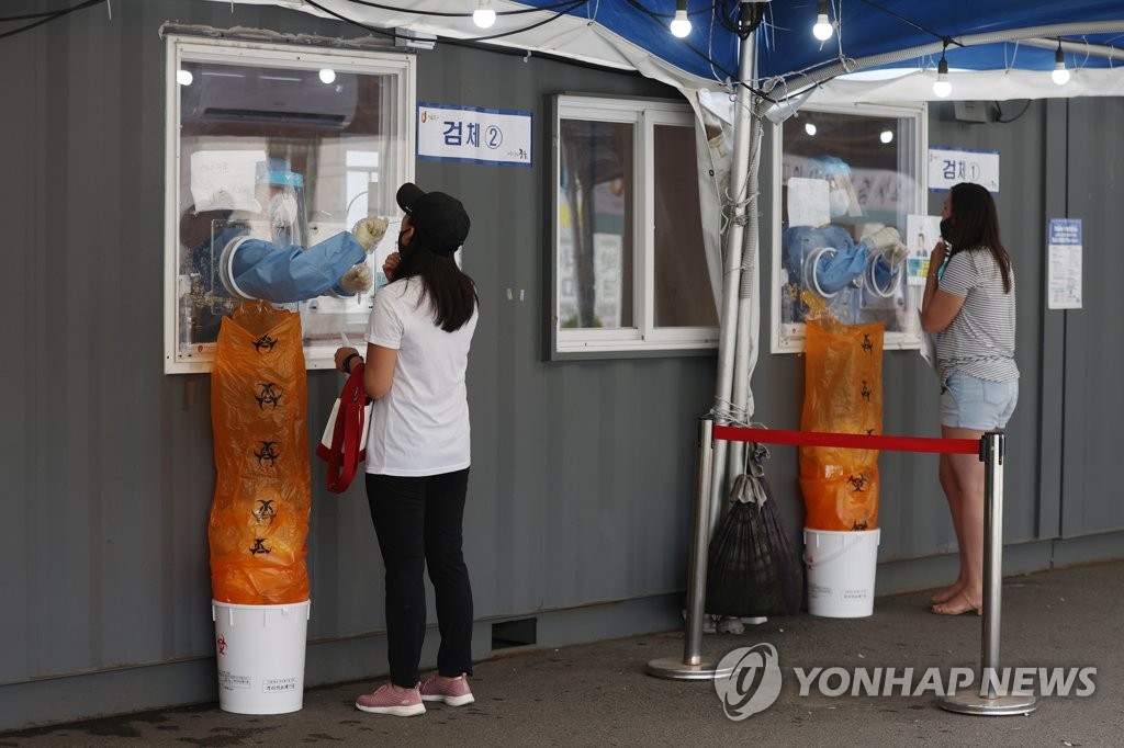 Medical workers conduct COVID-19 tests at a makeshift testing center near Seoul Station on Aug. 8, 2021. (Yonhap) 