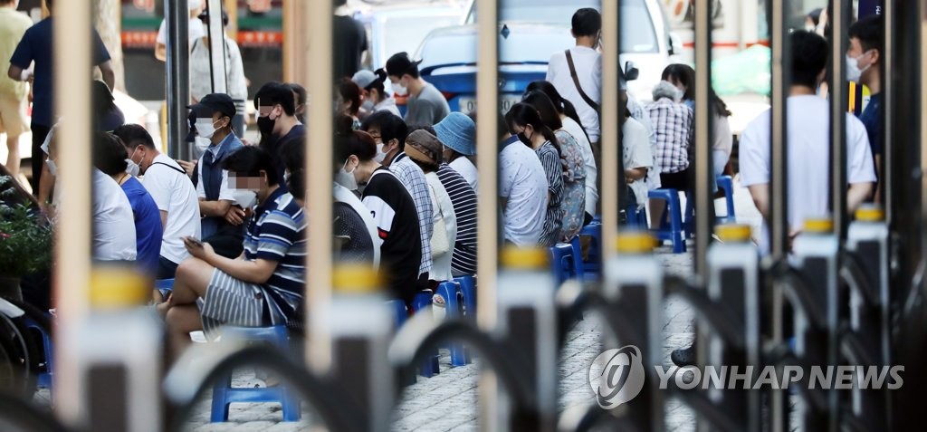 ソウル市内の新型コロナウイルス検査所で検査の順番を待つ市民＝１７日、ソウル（聯合ニュース）