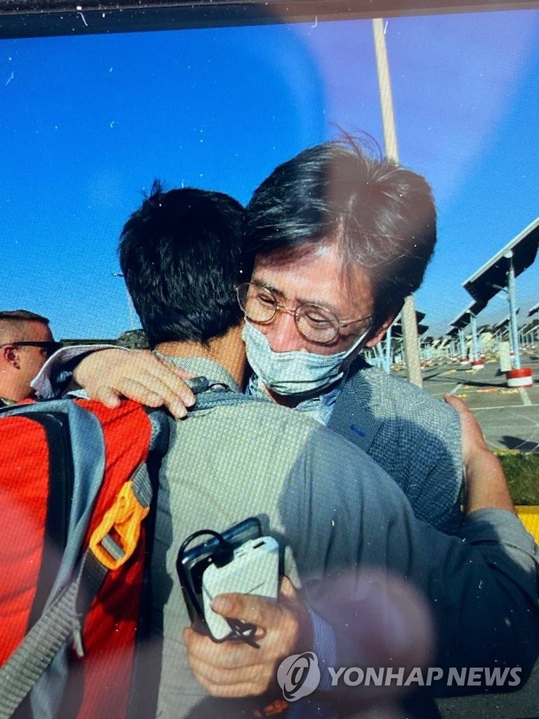Minister Counsellor Kim Il-eung of the South Korean Embassy in Kabul hugs an Afghan as he leads an evacuation mission in this undated photo, released on Aug. 25, 2021, by the foreign ministry. (PHOTO NOT FOR SALE) (Yonhap)