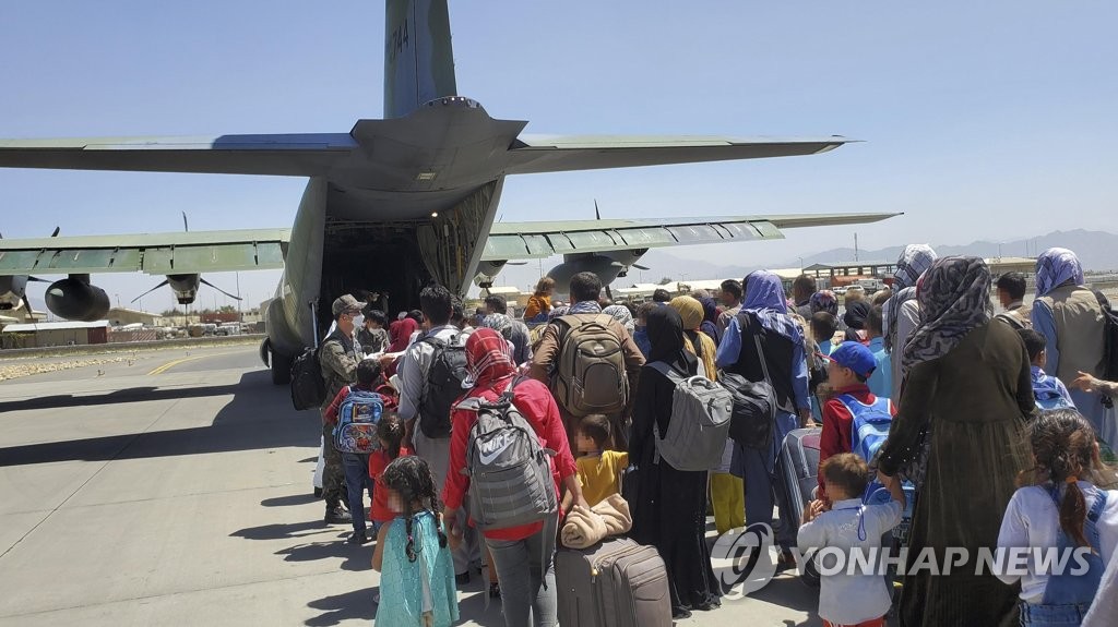 Some 380 Afghans who have worked for South Koreans in their war-ravaged nation and their family members board a South Korea military plane at an airport in Kabul on Aug. 25, 2021, to head for South Korea, in this photo provided by the Air Force. (PHOTO NOT FOR SALE) (Yonhap)