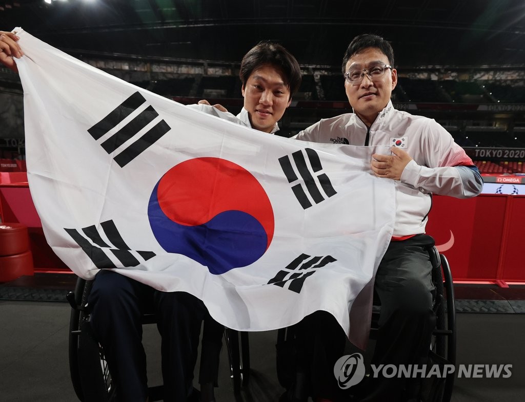 卓球男子シングルス（車いす１）で金メダルを獲得したチュ・ヨンデ（右）＝３０日、東京（聯合ニュース）