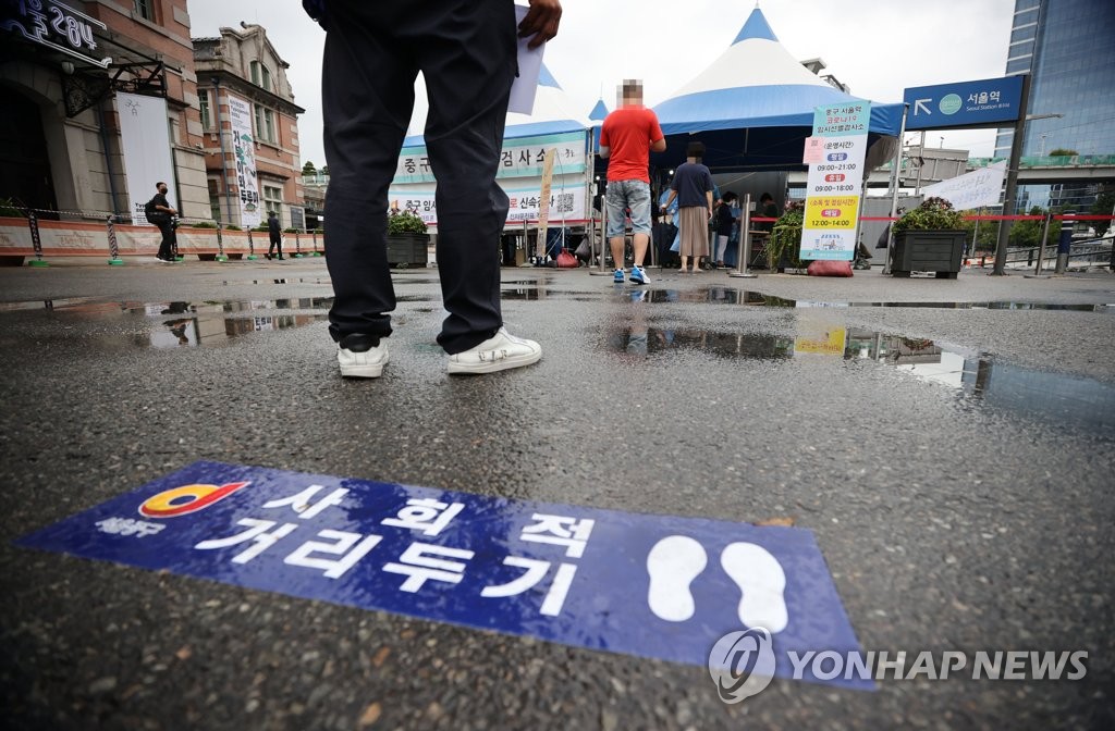 Des gens font la queue pour passer un test de dépistage du nouveau coronavirus (Covid-19) devant le centre installé sur la place de la gare de Séoul, le mardi 21 septembre 2021.