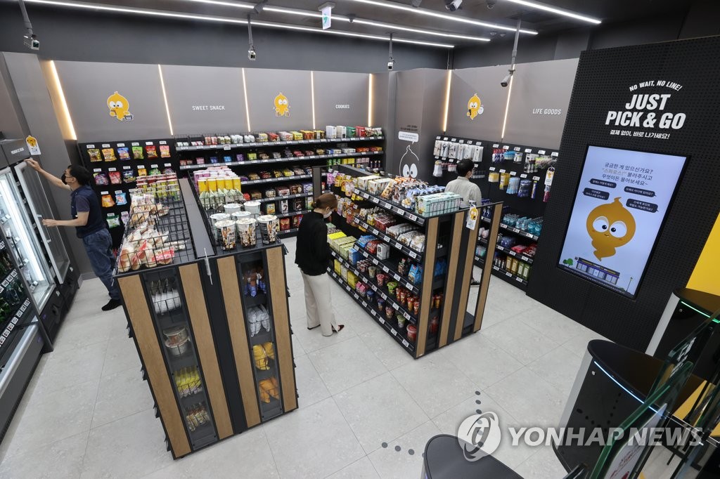 In this file photo, customers examine products on the shelves of Emart 24's first staff-free, grab-and-go store located in COEX Mall in southern Seoul on September 23, 2021. (PHOTO NOT FOR SALE) (Yonhap)