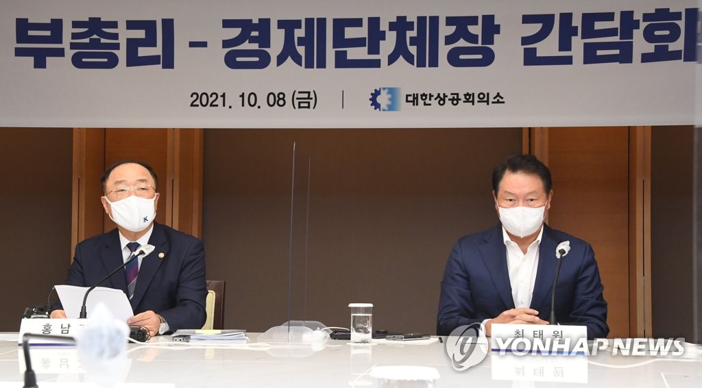 This photo, provided by the Ministry of Economy and Finance on Oct. 8, 2021, shows Finance Minister Hong Nam-ki (L) speaking at a meeting with the heads of five business lobby groups, including Chey Tae-won, chief of the Korea Chamber of Commerce and Industry (R). (PHOTO NOT FOR SALE) (Yonhap)