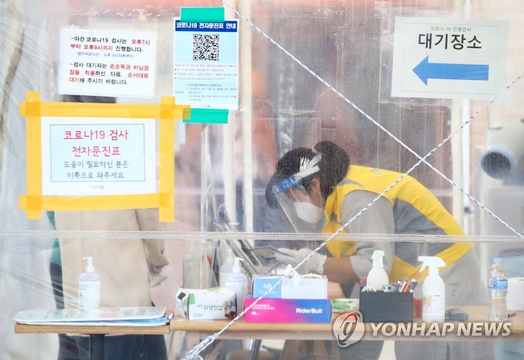 A health worker guides citizens at a makeshift COVID-19 testing clinic in Seoul on Oct. 10, 2021. (Yonhap)
