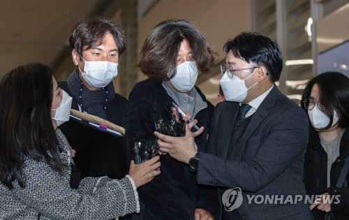 Nam Wook (C), a key figure in a sprawling land development scandal in Seongnam, Gyeonggi Province, is swarmed by reporters at Incheon International Airport, west of Seoul, on Oct. 18, 2021, after returning from Los Angeles to be questioned by prosecutors on his suspected role in lobbying influential figures over the course of pushing for the project. (Yonhap) 