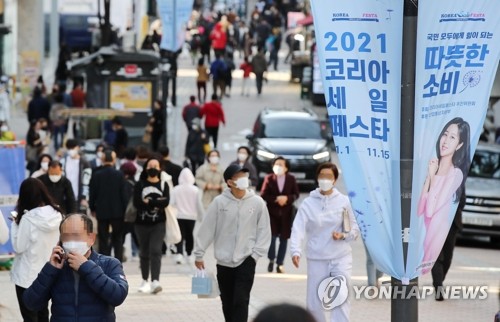 La foto, tomada el 7 de noviembre de 2021, muestra a las personas caminando por el barrio comercial de Myeongdong, en el centro de Seúl, mientras se está llevando a cabo un festival de compras liderado por el Estado.