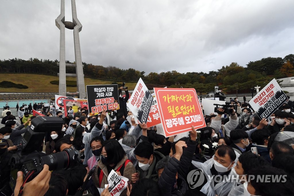 Protesters block a path to prevent People Power Party presidential candidate Yoon Seok-youl from visiting the May 18th National Cemetery in Gwangju on Nov. 10, 2021. (Pool photo) (Yonhap)