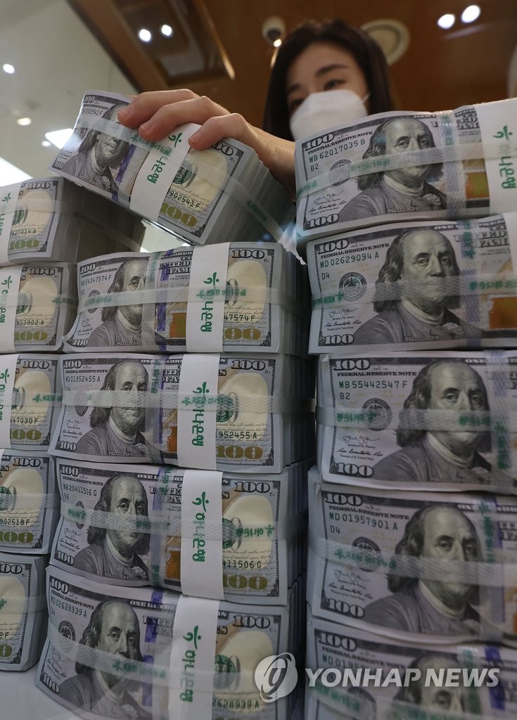 A clerk sorts US$100 banknotes at the headquarters of Hana Bank in Seoul on Dec. 3, 2021. South Korea's foreign exchange reserves had come to US$463.91 billion as of end-November, marking the first drop in five months due to a decline in the dollar-converted value of assets denominated in other foreign currencies, central bank data showed. (Yonhap)