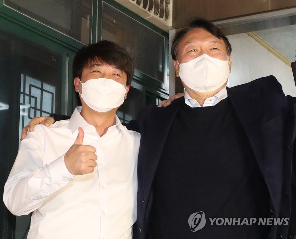 Yoon Seok-youl (R), the presidential nominee of the main opposition People Power Party, and party leader Lee Jun-seok pose for a photo after having dinner in the southeastern city of Ulsan on Dec. 3, 2021, in the wake of their feud about disagreements over election-related affairs. (Yonhap) 