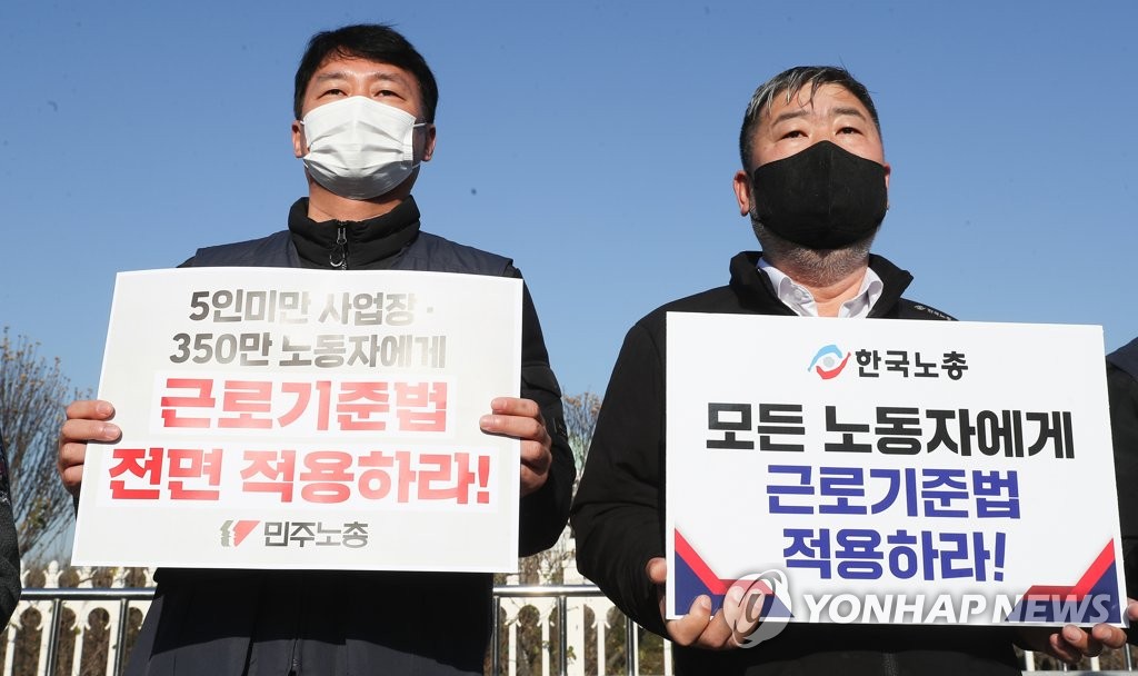 This Dec. 8, 2021, file photo shows the chiefs of South Korea's two major umbrella labor unions -- the Korean Confederation of Trade Unions (L) and the Federation of Korean Trade Unions -- calling for universal implementation of the Labor Standards Act in a news conference held in front of the National Assembly Complex in southern Seoul. (Yonhap)