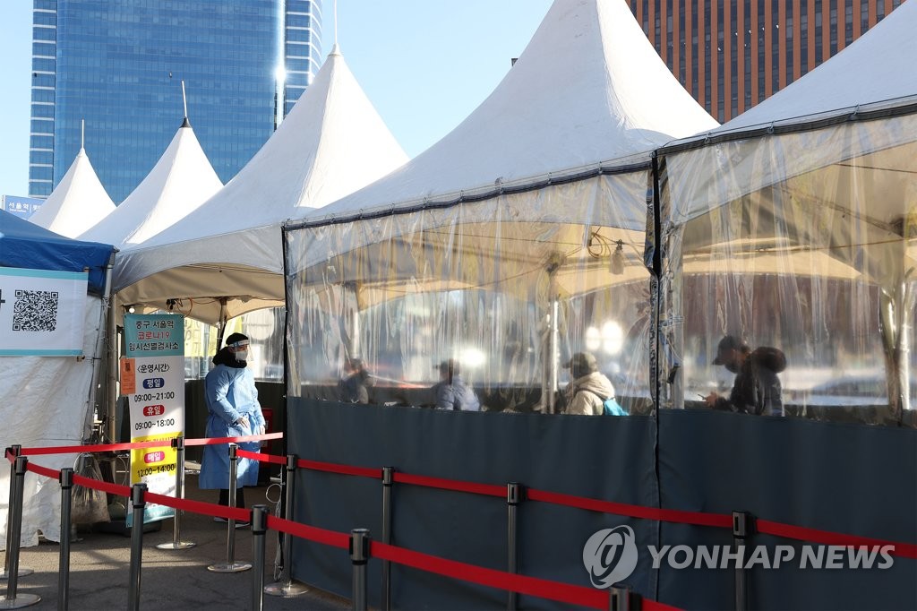En la imagen, tomada el 1 de enero de 2022, se muestra una fila de personas para la prueba del coronavirus en un centro de exámenes preparado en una plaza frente a la Estación de Seúl, en el centro de la capital surcoreana.