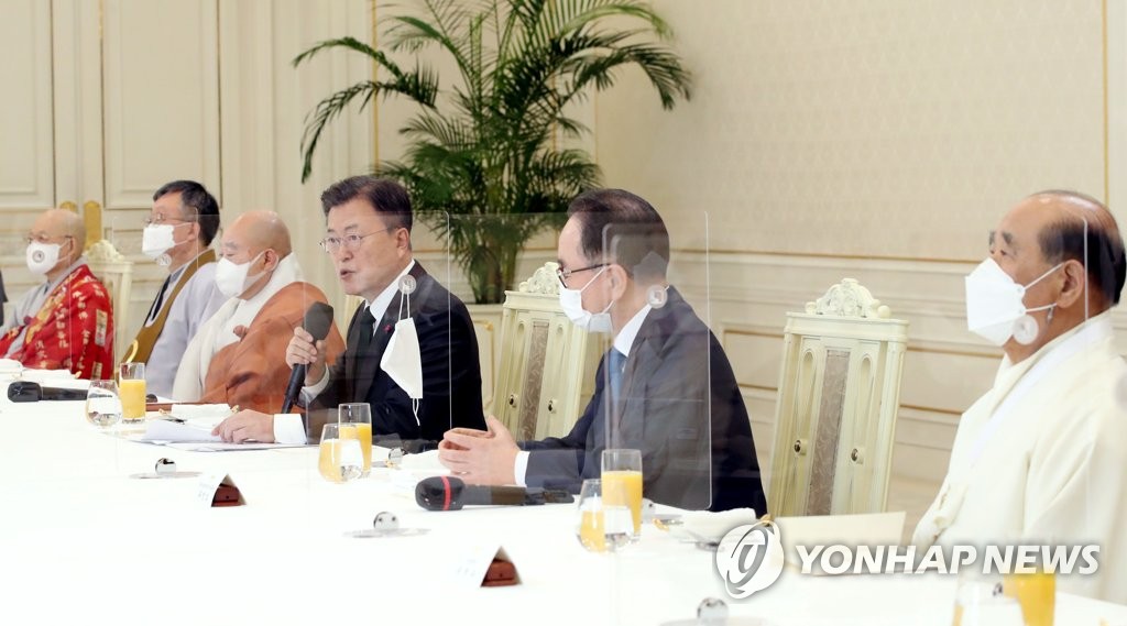 El presidente surcoreano, Moon Jae-in (tercero por la dcha.), habla durante una reunión de almuerzo con los líderes de las principales religiones surcoreanas, el 12 de enero de 2022, en la oficina presidencial, en Seúl.