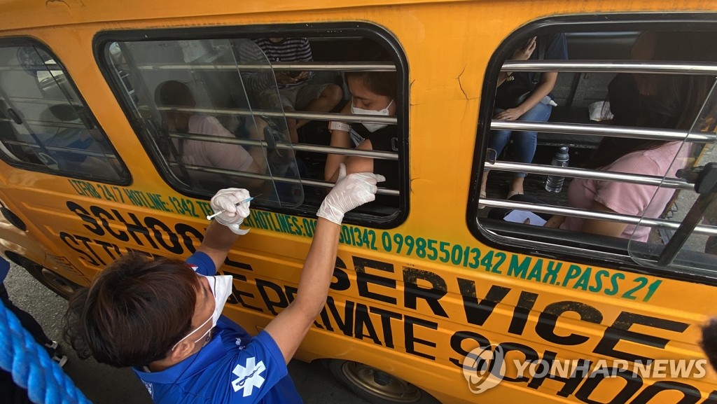 오미크론 확산 속 버스 안에서 백신 맞는 필리핀인들