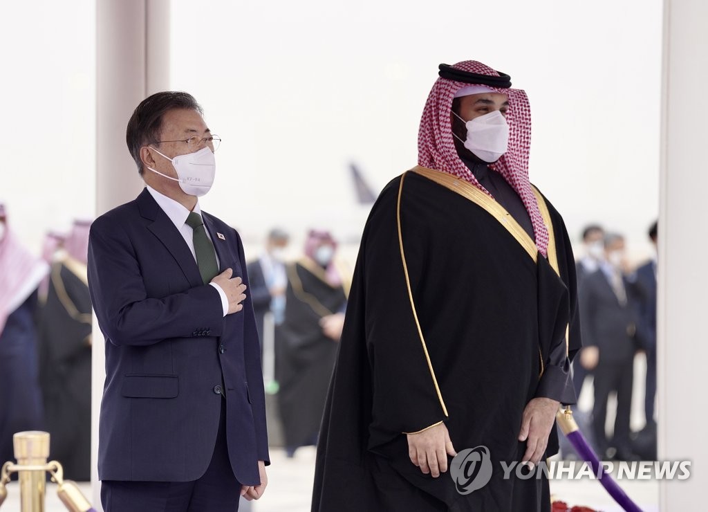 El presidente de Corea del Sur, Moon Jae-in (izq.), y el príncipe heredero de Arabia Saudita, Mohamed bin Salmán, asisten, el 18 de enero de 2022, a una ceremonia de bienvenida oficial tras llegar al Aeropuerto Internacional Rey Khalid, en Riad.