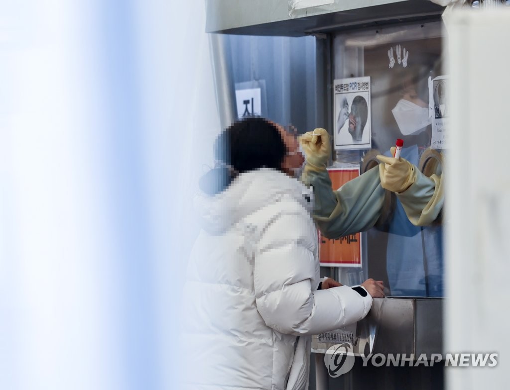 A citizen undergoes a COVID-19 test at a makeshift testing station at Seoul's Yongsan Station on Jan. 22, 2022. (Yonhap)