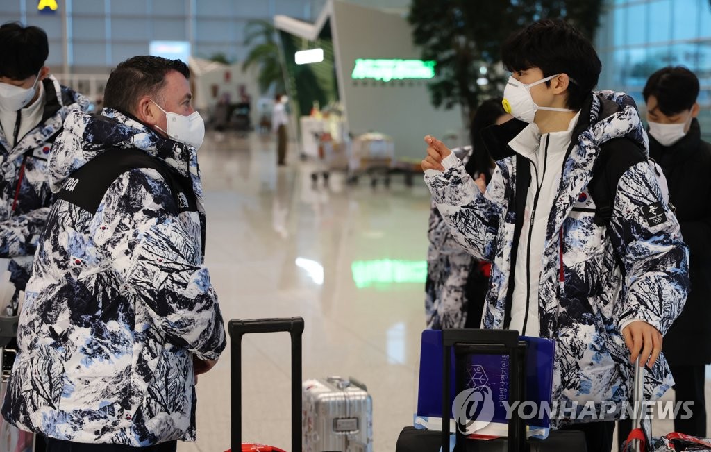 South Korean figure skater Cha Jun-hwan (R) speaks with his coach, Brian Orser, at Incheon International Airport in Incheon, just west of Seoul, on Feb. 3, 2022, before leaving for Beijing for the 2022 Winter Olympics. (Yonhap)