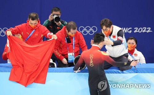 ショートトラック男子１０００メートル決勝でビデオ判定の末に金メダルを獲得した中国の選手を迎えるキム・ソンテ監督（手前右）＝７日、北京（聯合ニュース）
