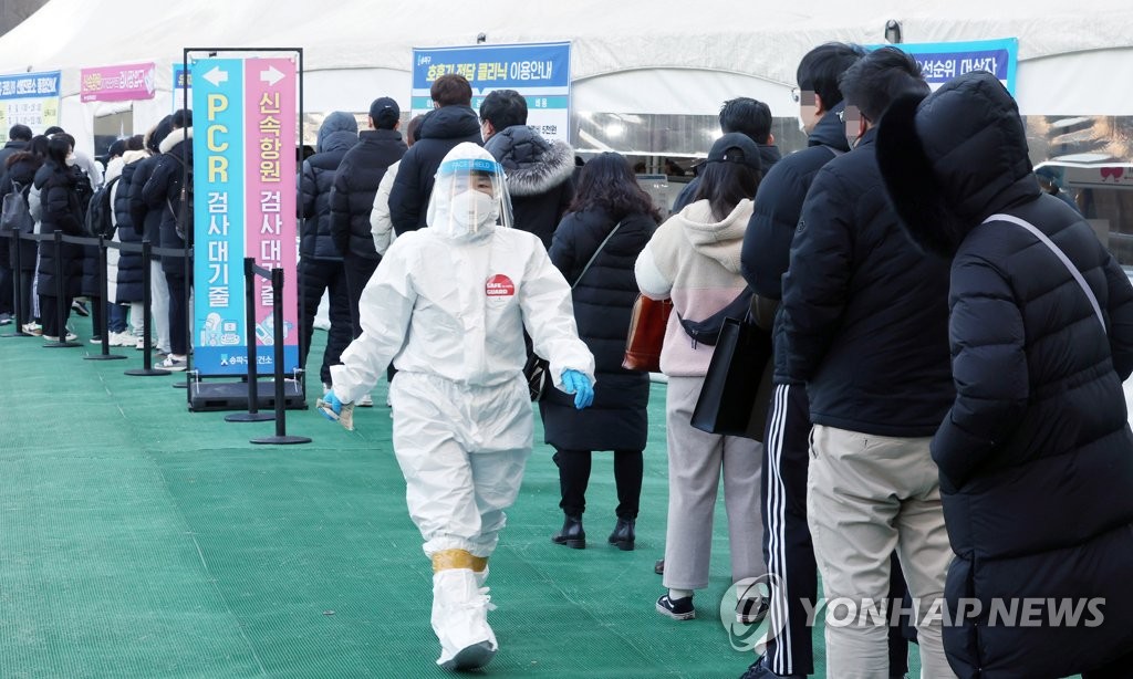People wait in line to receive tests at a COVID-19 testing station in Seoul on Feb. 9, 2022. (Yonhap)