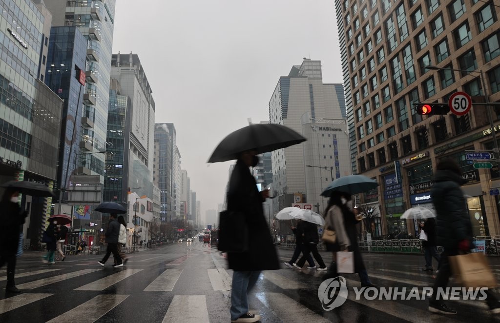 서울 마포구 홍대 거리에서 우산을 쓴 시민들이 길을 건너고 있다. [연합뉴스 자료사진]