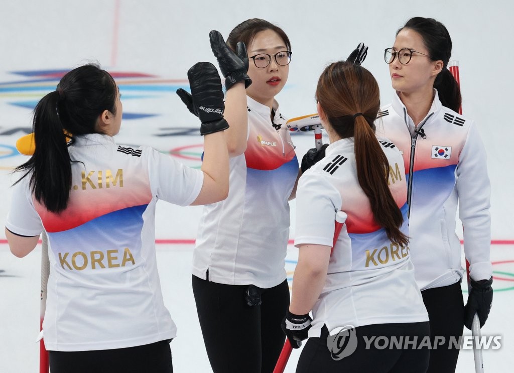 South Korean curlers Kim Kyeong-ae, Kim Cho-hi, Kim Yeong-mi and Kim Eun-jung (L to R) celebrate a point against Japan during the women's curling round-robin match at the Beijing Winter Olympics at the National Aquatics Centre on Feb. 14, 2022. (Yonhap)