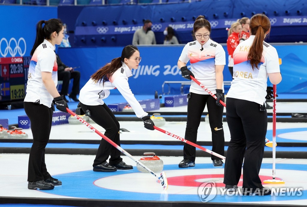 South Korean curlers Kim Kyeong-ae, Kim Eun-jung, Kim Cho-hi and Kim Yeong-mi (L to R) discuss their next move against Japan during the women's curling round-robin match at the Beijing Winter Olympics at the National Aquatics Centre on Feb. 14, 2022. (Yonhap)