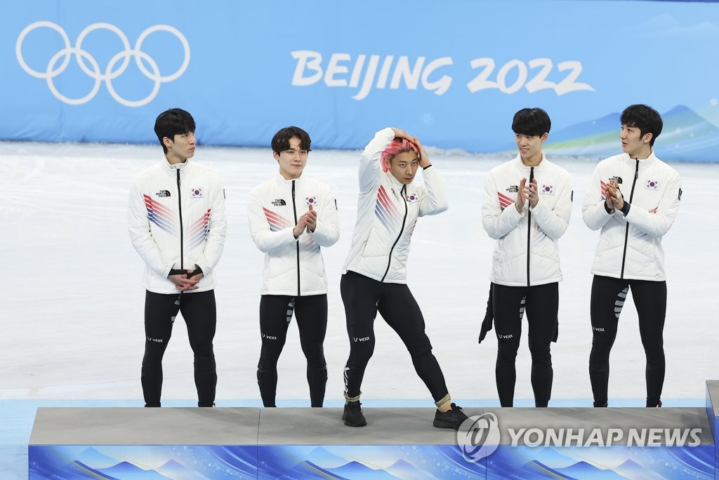 Kwak Yoon-gy (au c.) danse sur le podium alors que ses coéquipiers Hwang Dae-heon, Kim Dong-wook, Lee June-seo et Park Jang-hyuk (de g. à dr.) le regardent pendant la cérémonie de remise des médailles pour le relais masculin de patinage de vitesse sur piste courte sur 5.000m aux Jeux olympiques d'hiver de Pékin au Palais omnisports de la capitale à Pékin, le 16 février 2022.