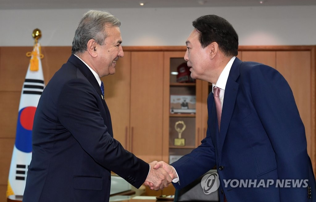 Le président entrant Yoon Suk-yeol (à droite) serre la main de Sodiq Safoyev, premier vice-président du Sénat du Parlement ouzbek, au bureau du comité de transition présidentielle à Séoul, le 9 mai 2022. (Pool photo) (Yonhap) 