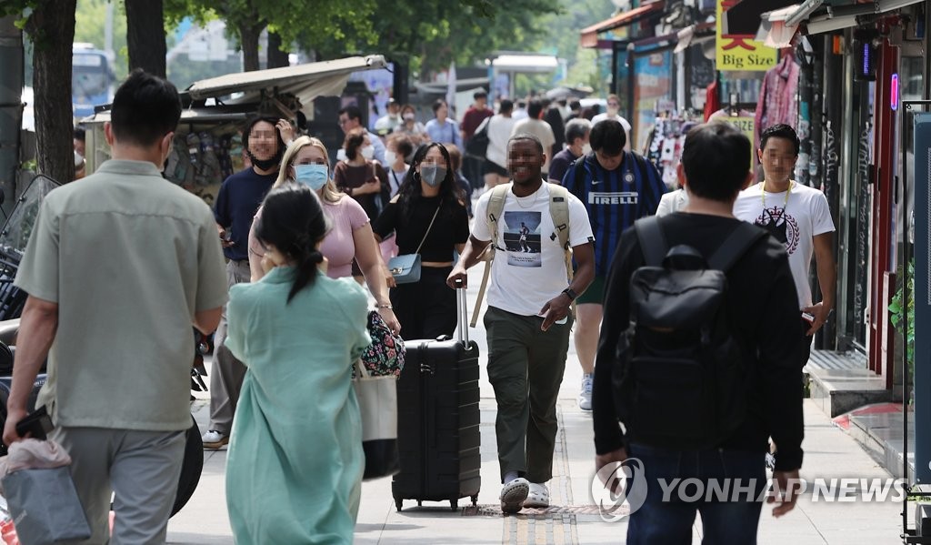Foreign tourists walk on a street in Seoul's Itaewon district, in this May 29, 2022, file photo. (Yonhap)