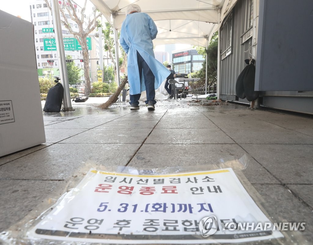 A medical worker sweeps the floor at a COVID-19 testing station in Seoul's central district of Jongno on May 31, 2022, a day before its closure as South Korea is set to remove most of the makeshift booths amid a decline in infections. (Yonhap) 