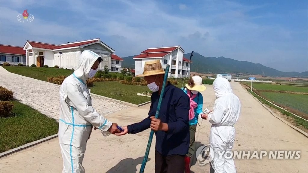농장원들 체온측정하는 북한 방역원