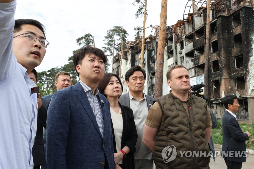 En la foto, proporcionada, el 7 de junio de 2022, por el PPP, se muestra a su presidente, Lee Jun-seok (2º por la izda.), y algunos de sus legisladores siendo informados sobre el daño en Irpín, Ucrania. (Prohibida su reventa y archivo)