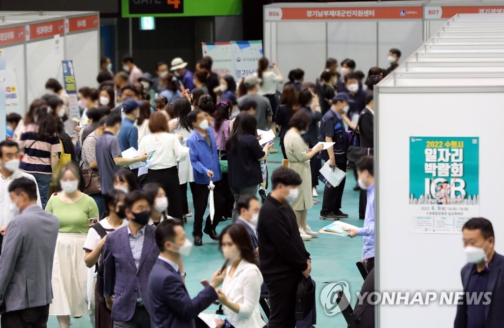 In this file photo, job seekers look at employment information at a job fair in Suwon, south of Seoul, on June 9, 2022. (Yonhap)