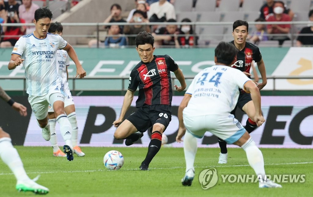 Hwang In-beom of FC Seoul (C) takes a shot against Ulsan Hyundai FC during the clubs' K League 1 match at Seoul World Cup Stadium in Seoul on June 22, 2022. (Yonhap)