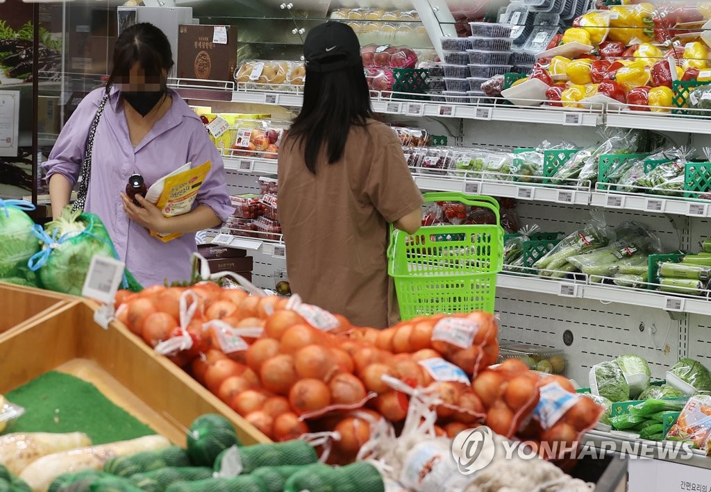 In this file photo, shoppers select vegetables at a supermarket in Seoul on June 26, 2022. The average food bill for a four-person household in the first quarter of 2022 jumped 9.7 percent on-year to 1.06 million won (US$823), according to the data compiled by Statistics Korea. (Yonhap)