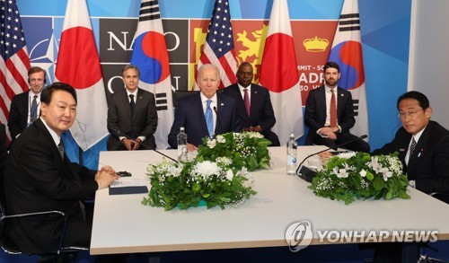 This file photo, taken June 29, 2022, shows South Korean President Yoon Suk-yeol (L), U.S. President Joe Biden (C) and Japanese Prime Minister Fumio Kishida holding a trilateral summit in Madrid. (Yonhap)