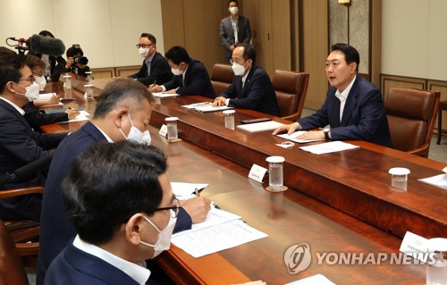 El presidente surcoreano, Yoon Suk-yeol (dcha.), y los ministros asisten a la primera reunión de emergencia, que tuvo lugar, el 8 de julio de 2022, en la oficina presidencial, en Seúl, para elaborar medidas a fin de domar el alza de la inflación, como parte de los esfuerzos para mejorar los medios de vida del pueblo.