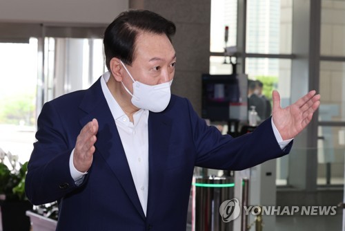大統領室庁舎に出勤し、記者団の質問に答える尹大統領＝２２日、ソウル（聯合ニュース）