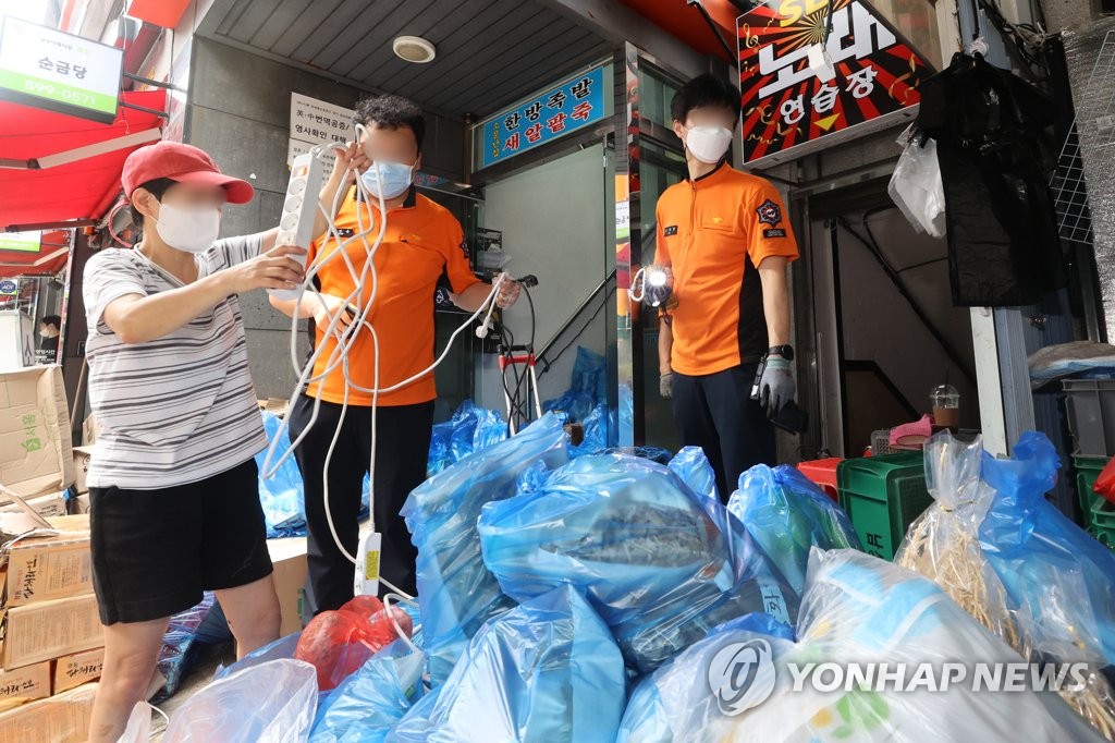 폭우 피해 전통시장 복구 돕는 소방관들